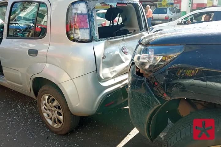 frente da caminhonte batida contra a traseira do uno, com o vidro quebrado e estilhaços