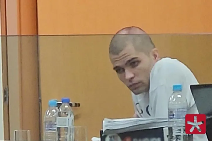 Fotografia mostrando o réu João Vitor Machado Dorneles durante o julgamento, trajando camiseta branca