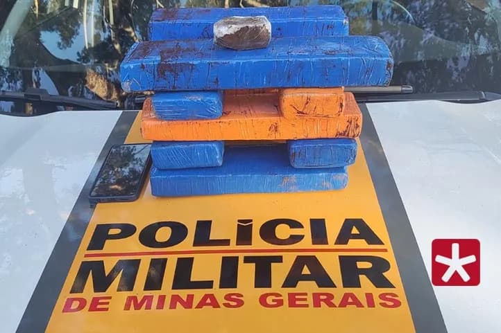 imagem colorida mostrando as barras de maconha emplilhadas sobre o capô da viatura da Polícia Militar Rodoviária