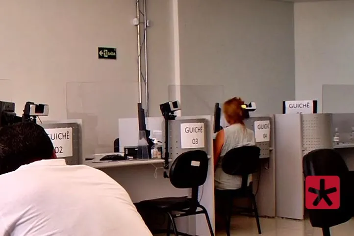 imagem colorida, mostrando mulher de costas sentada em uma cadeira para atendimento no cartorio eleitoral