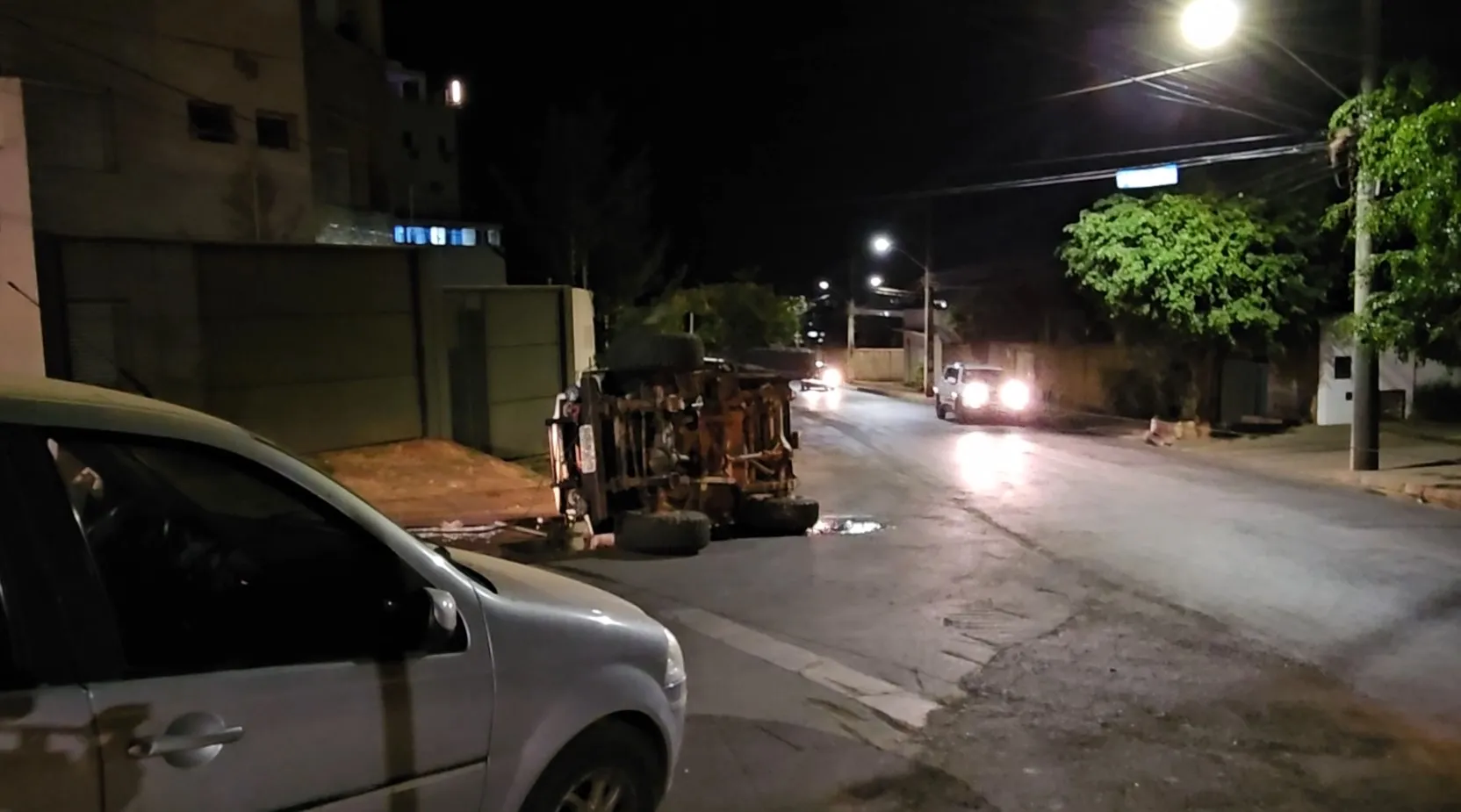 imagem colorida mostrando o veiculo toyota bandeirante tombado lateralmente após o capotamento na lateral da rua com vários estragos na estrutura